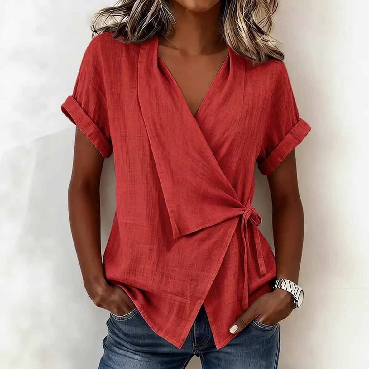 Red wrap top worn by a person against a white background