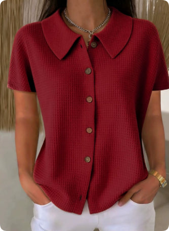 Red short-sleeve button-up shirt worn by a person with a neutral background