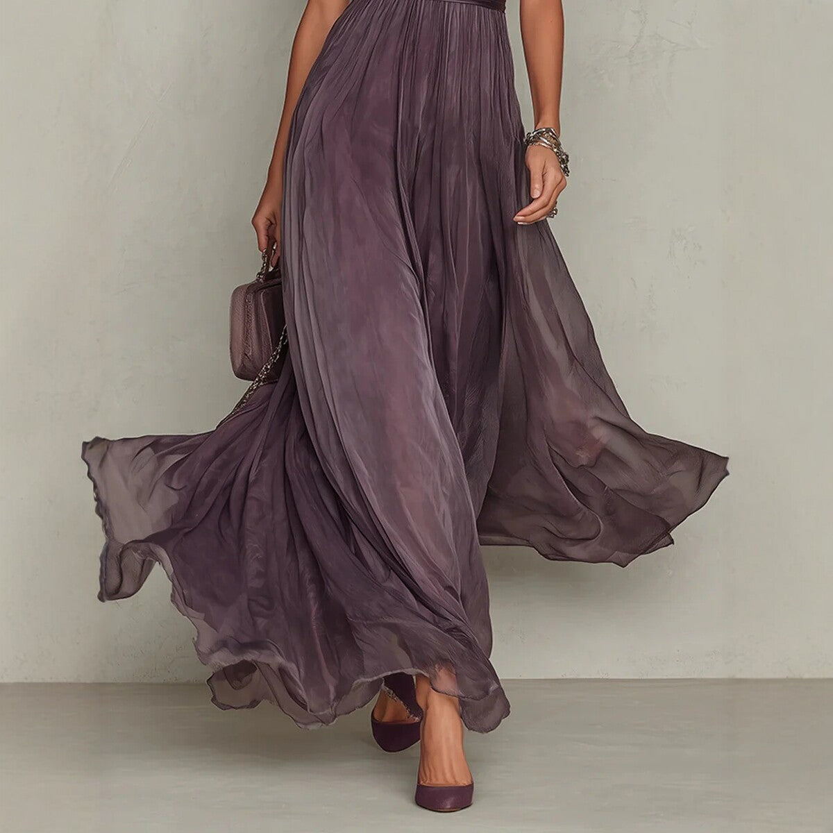 Woman wearing a long, flowing purple dress against a neutral background
