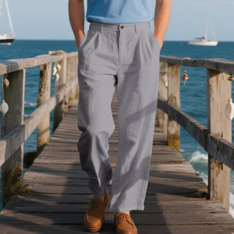 Person wearing gray pants and brown shoes on a wooden pier with ocean view