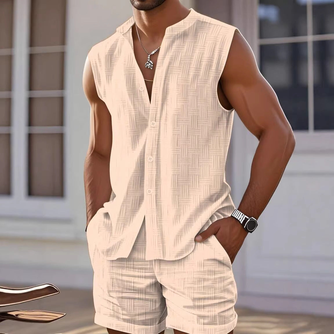Man wearing a beige sleeveless shirt and shorts set with a blurred background