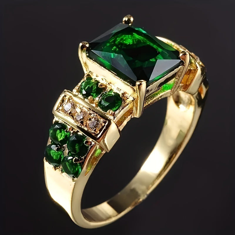 Gold ring with green gemstones on a black background