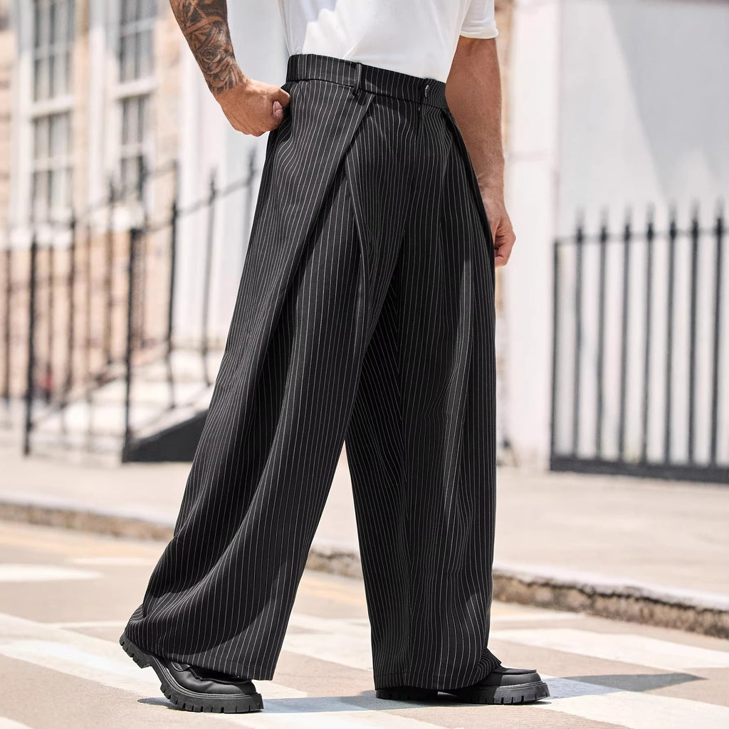 Person wearing black pinstripe wide-leg pants on a city street.