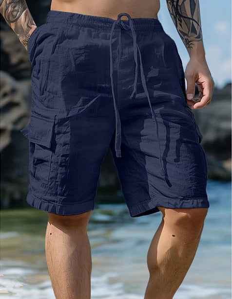Person wearing navy blue shorts with a subtle pattern on a beach.