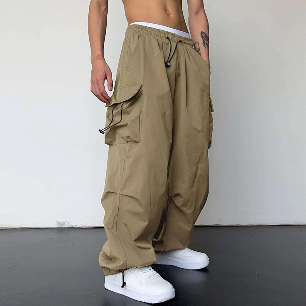Person wearing beige cargo pants and white sneakers on a plain background