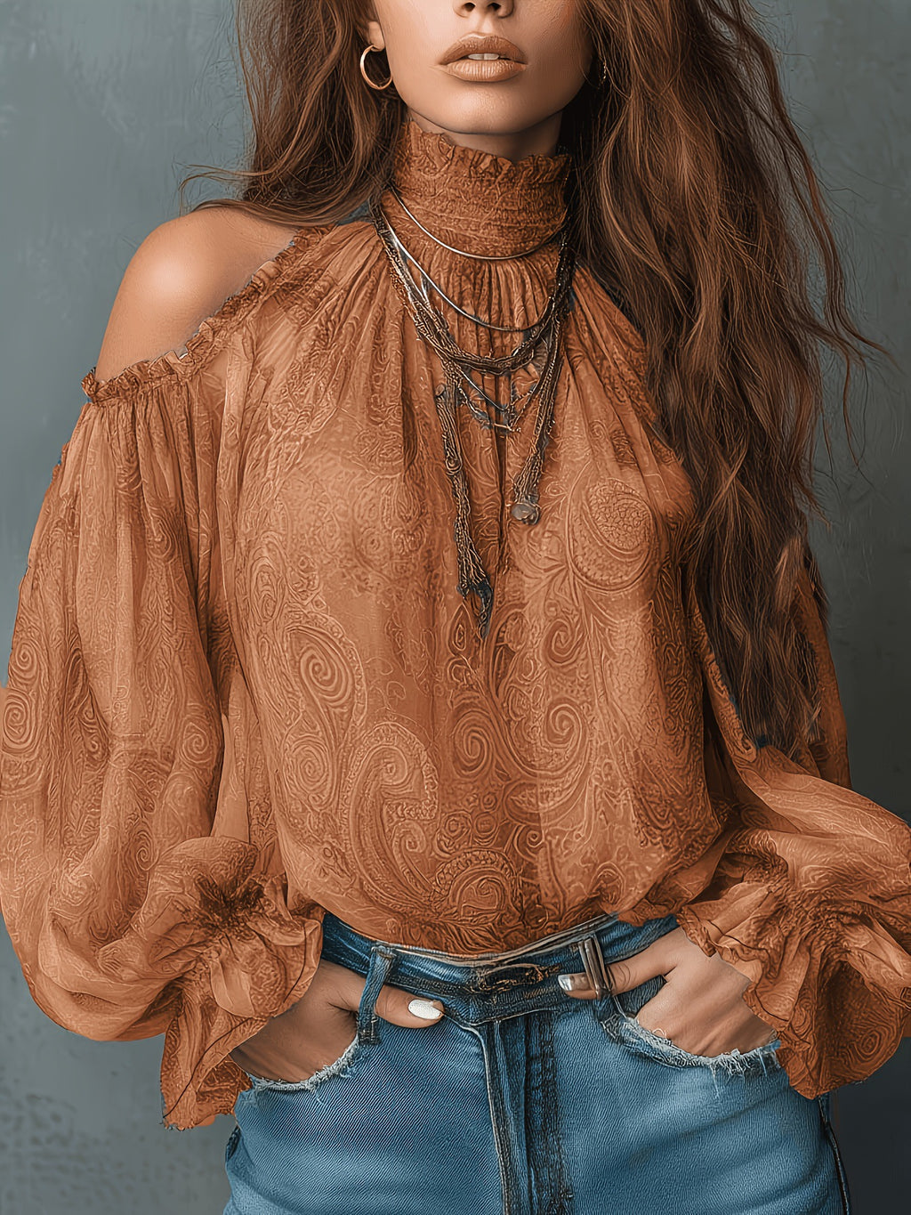 Woman wearing a brown patterned blouse and blue jeans against a gray background