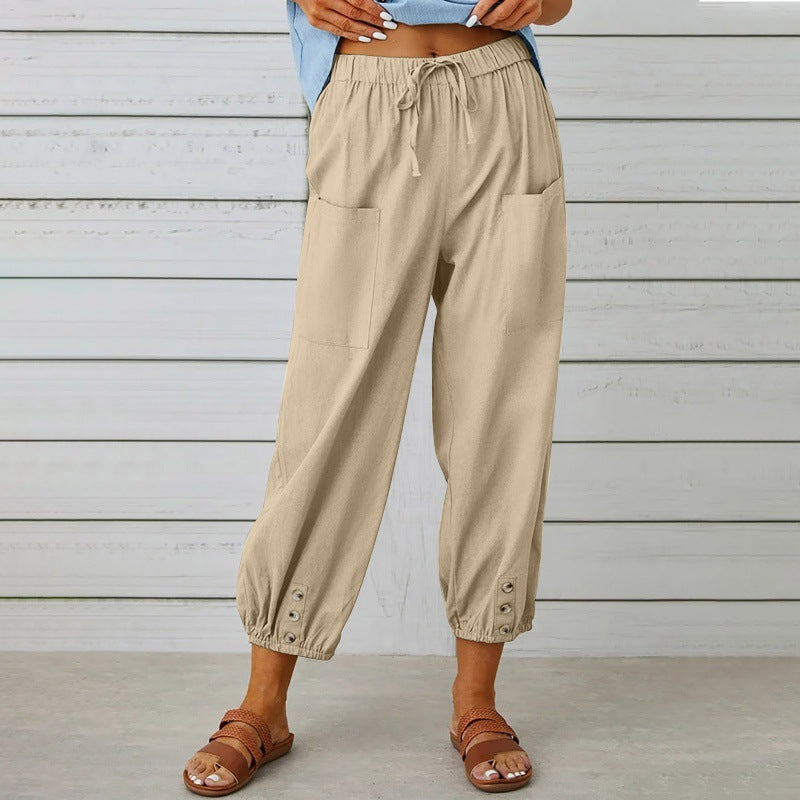 Beige pants worn by a person standing against a wooden wall.