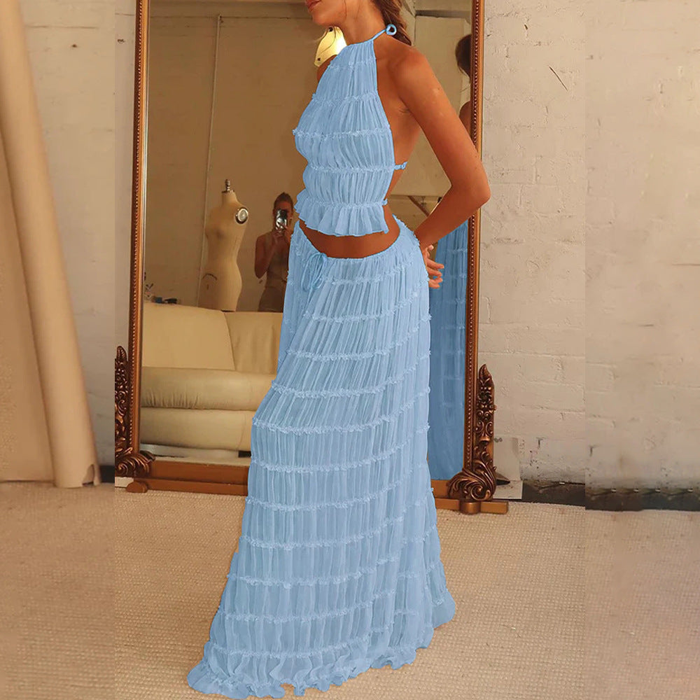 Woman wearing a light blue crochet dress standing in front of a mirror.