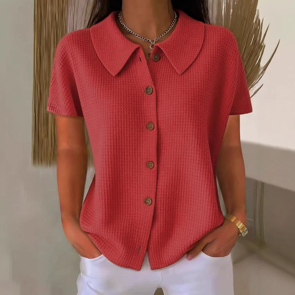 Red textured shirt with buttons worn by a person, against a neutral background