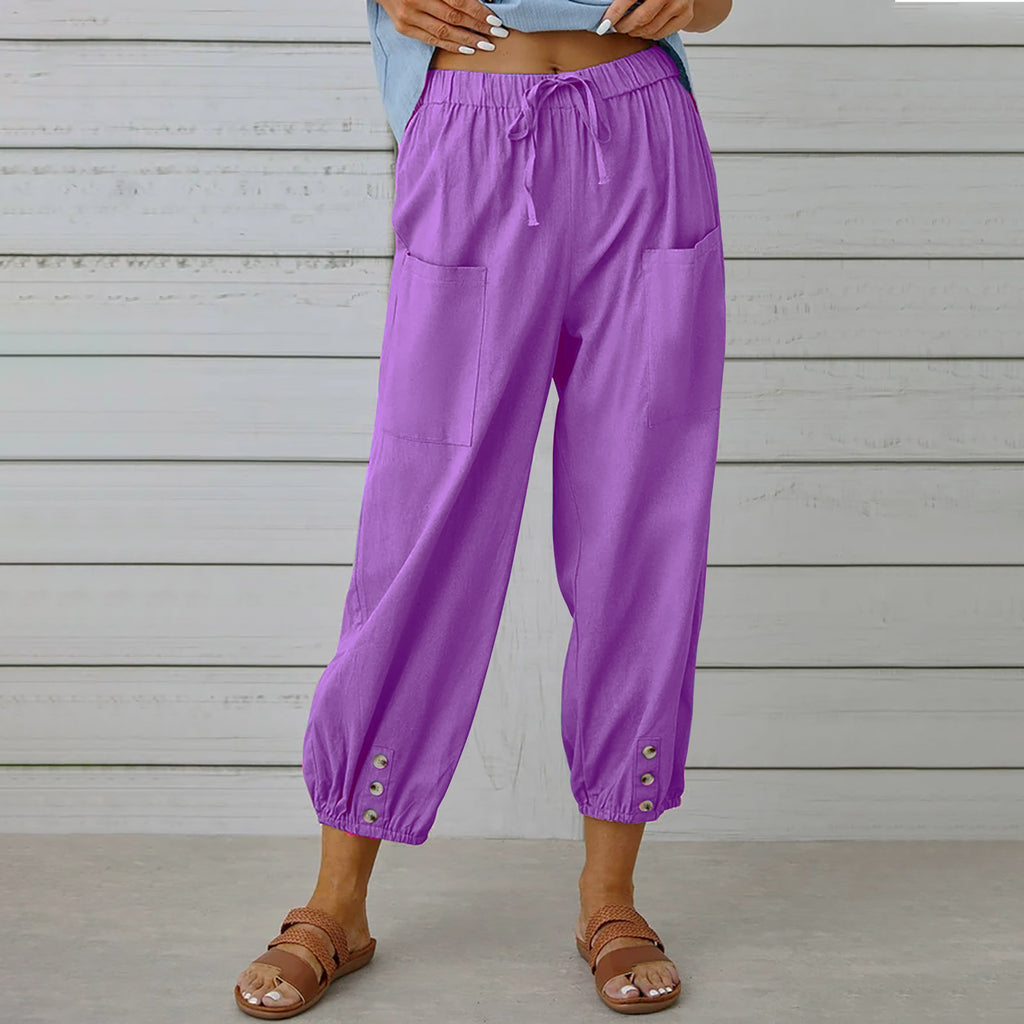 Purple pants worn by a person standing against a wooden wall.