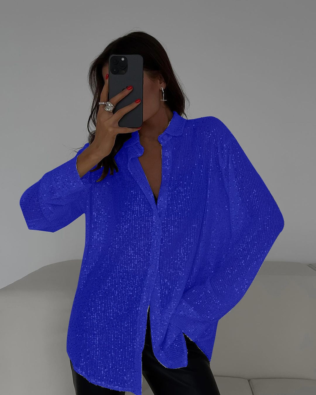 Person wearing a bright blue cardigan taking a mirror selfie.
