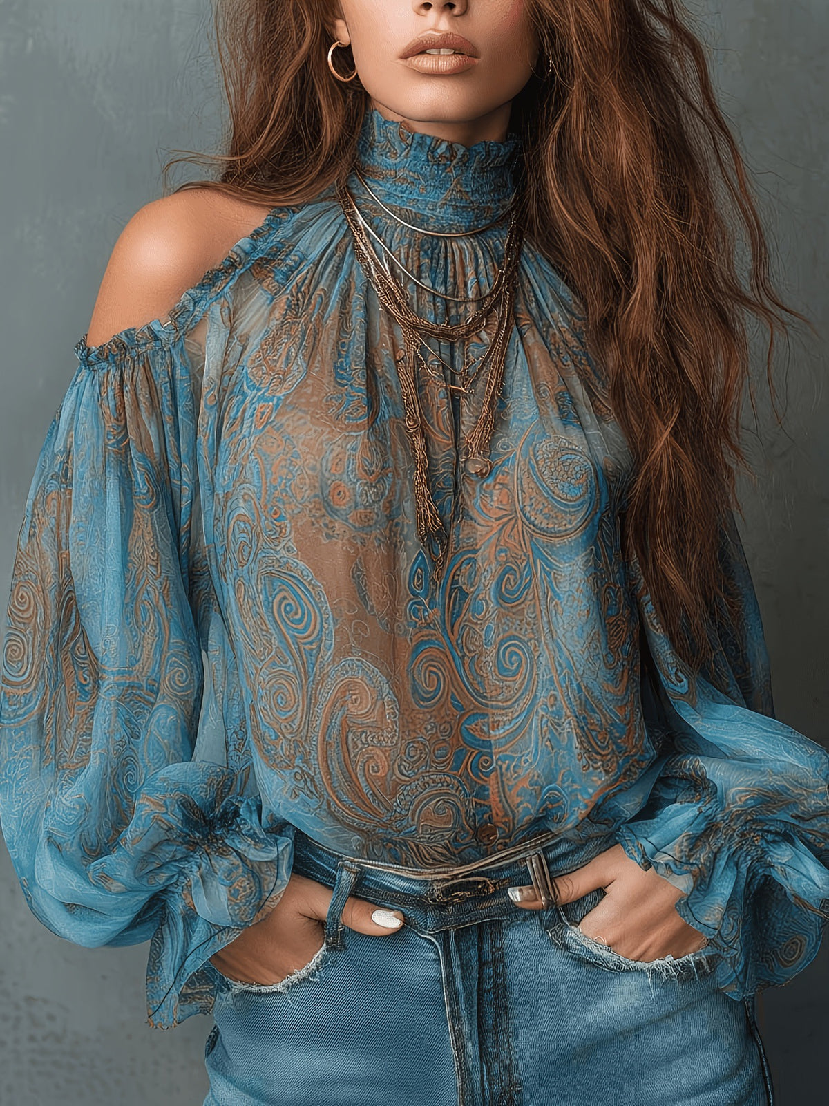 Woman wearing a blue patterned blouse and jeans against a gray background