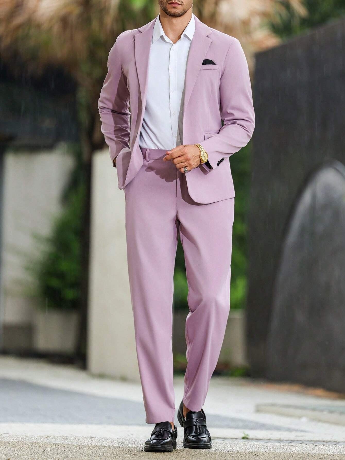 Man wearing a light purple suit with a white shirt, standing outdoors.