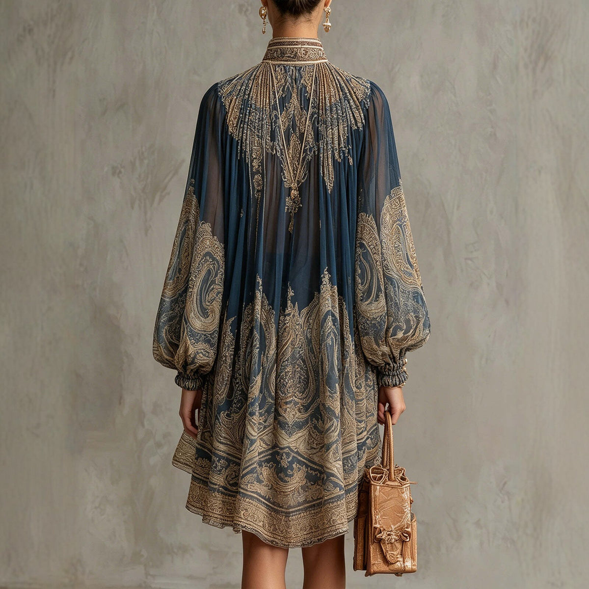 Woman wearing a patterned dress holding a bag against a textured wall.