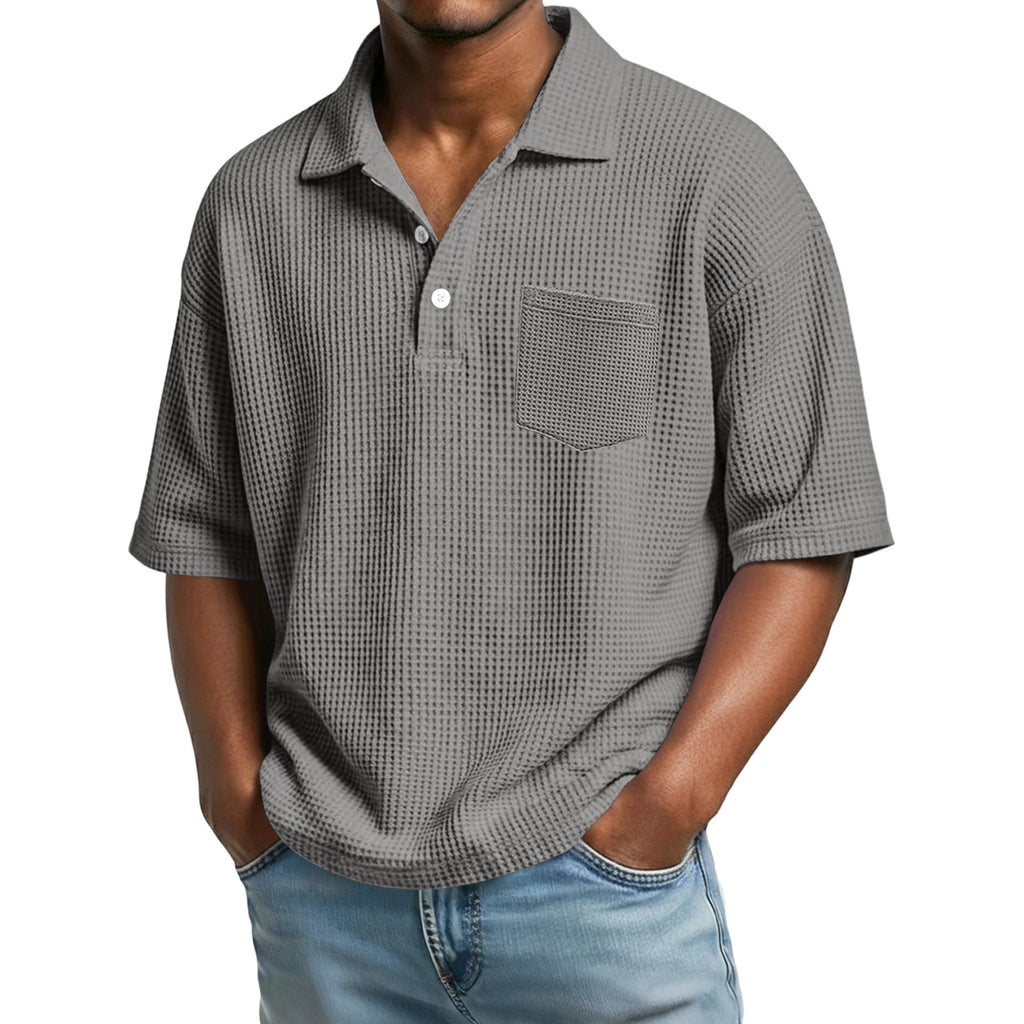 Man wearing a gray checkered polo shirt with a pocket on a white background