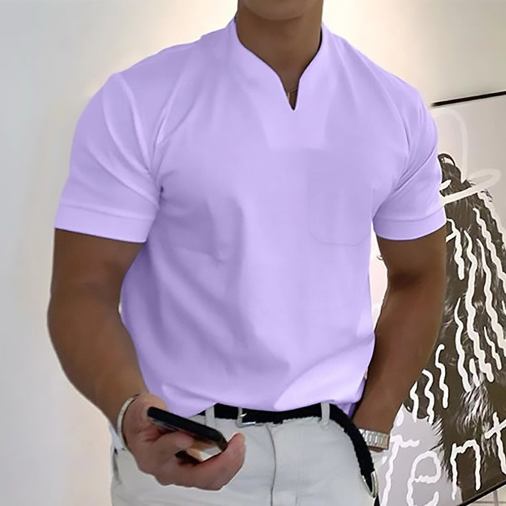 Person wearing a light purple shirt and white pants, holding a phone.