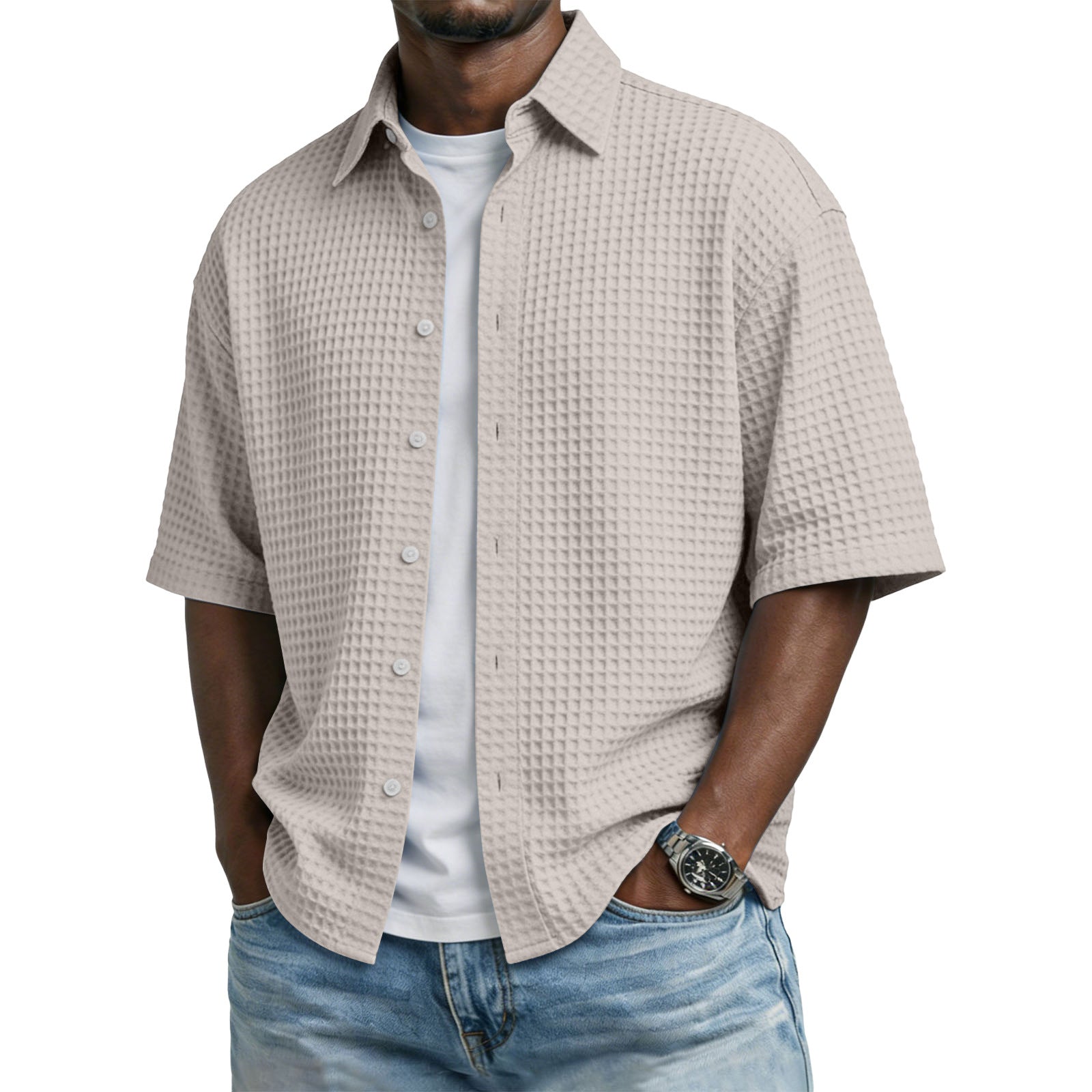 Man wearing a beige textured shirt over a white shirt with blue jeans on a white background
