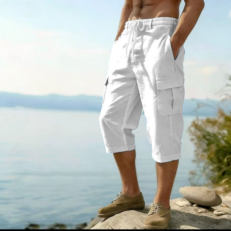 Person wearing white cargo shorts standing by a body of water.