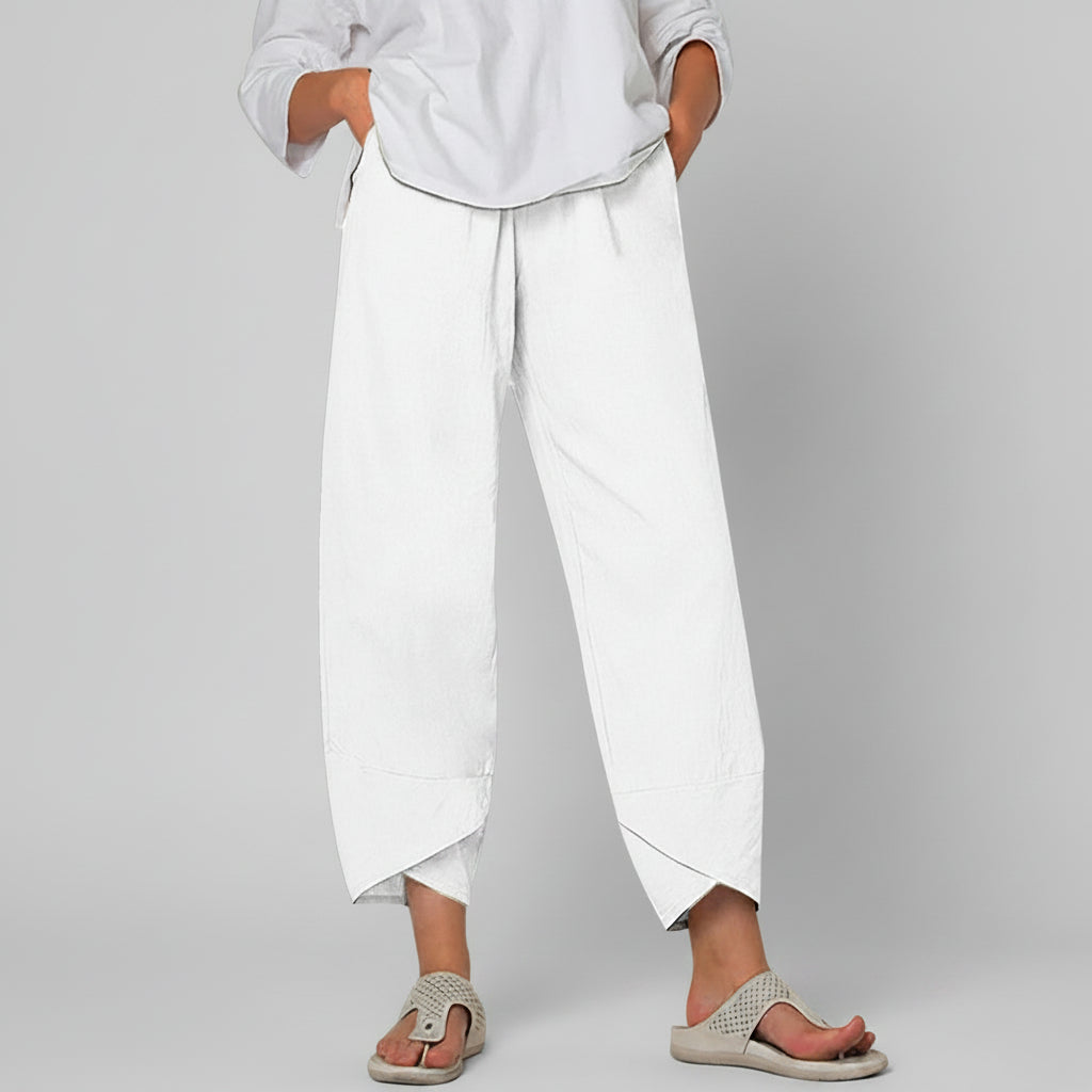 Person wearing white pants and sandals on a white background