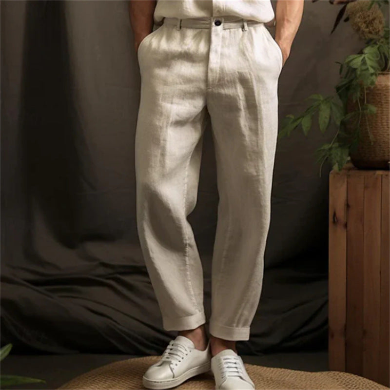 Person wearing white pants and white sneakers against a neutral background