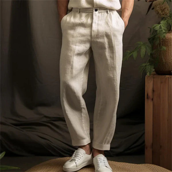 Person wearing white pants and white sneakers against a neutral background