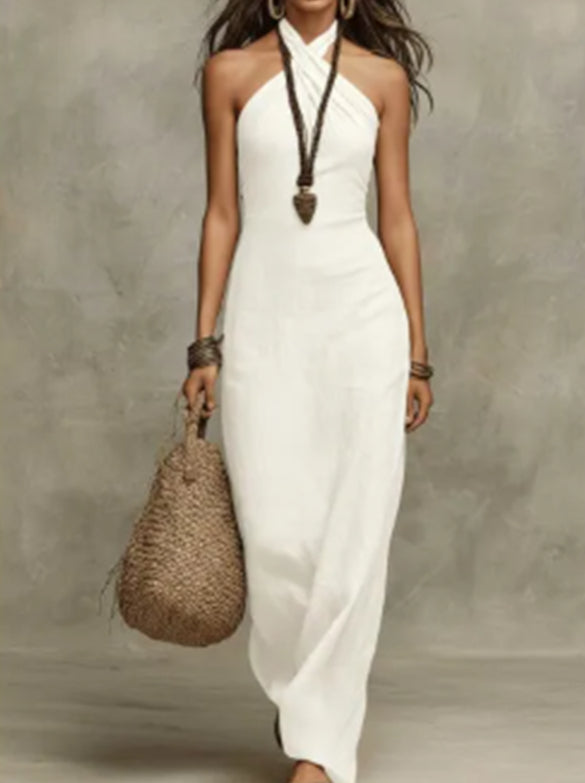 Woman in a white dress holding a woven bag against a gray background