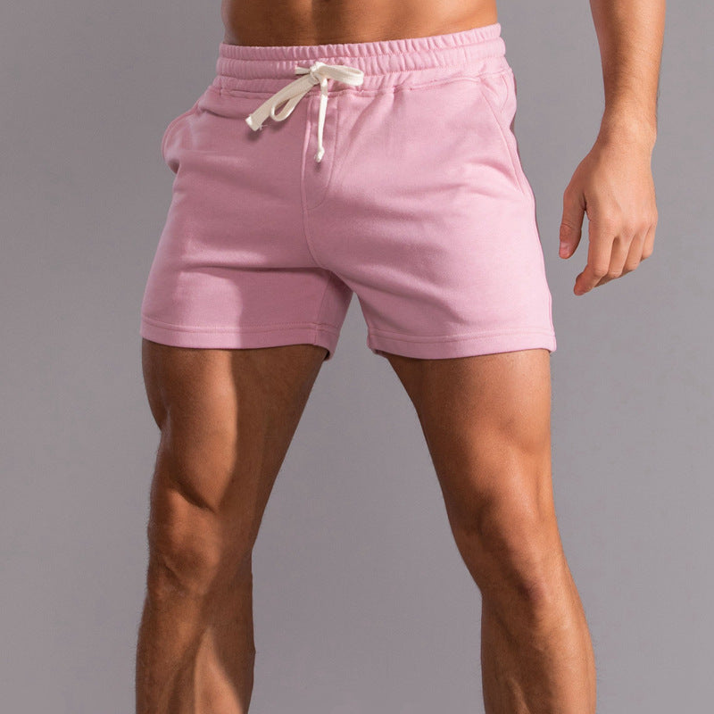 Pink shorts worn by a person on a gray background