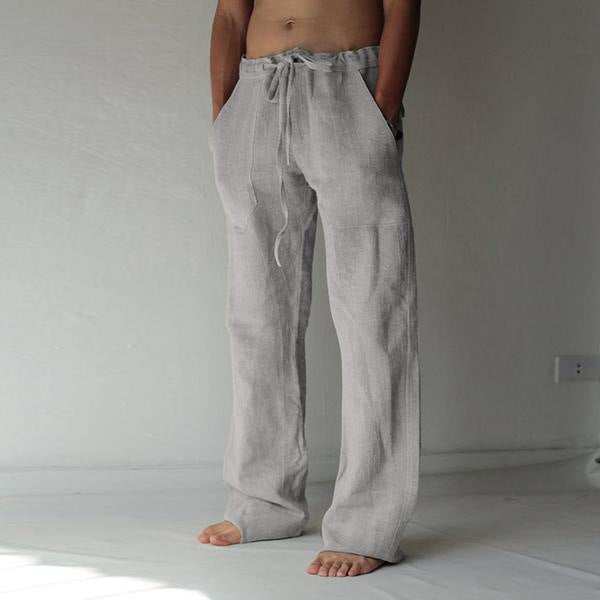 Person wearing light gray linen pants standing against a plain background