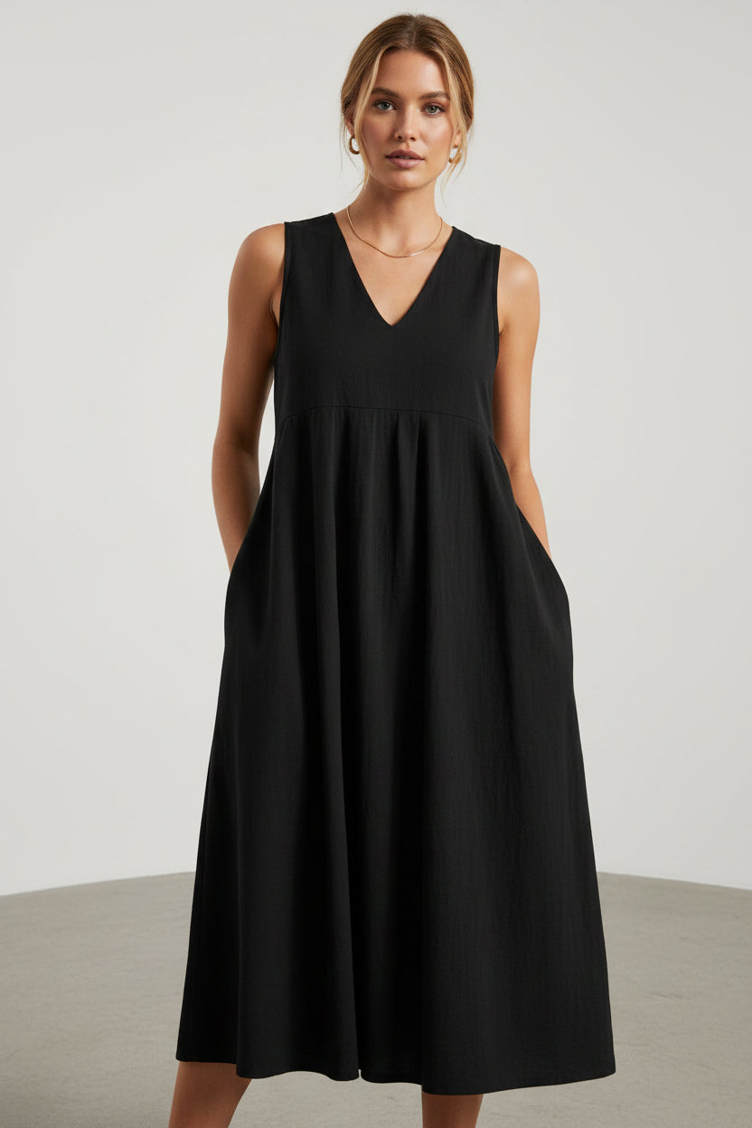 Black sleeveless dress worn by a person on a white background