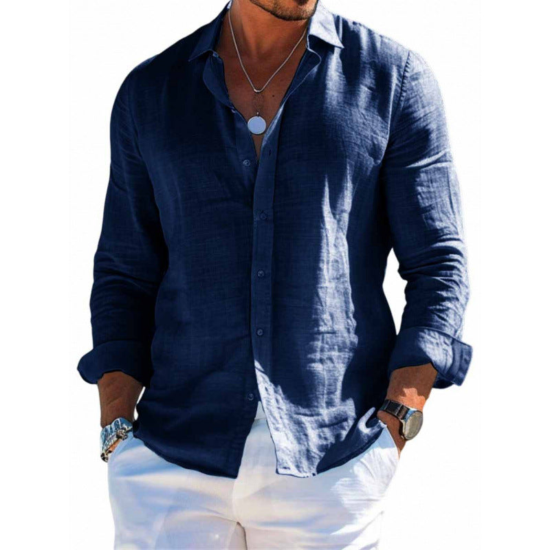 Man wearing a navy blue button-up shirt and white pants on a white background