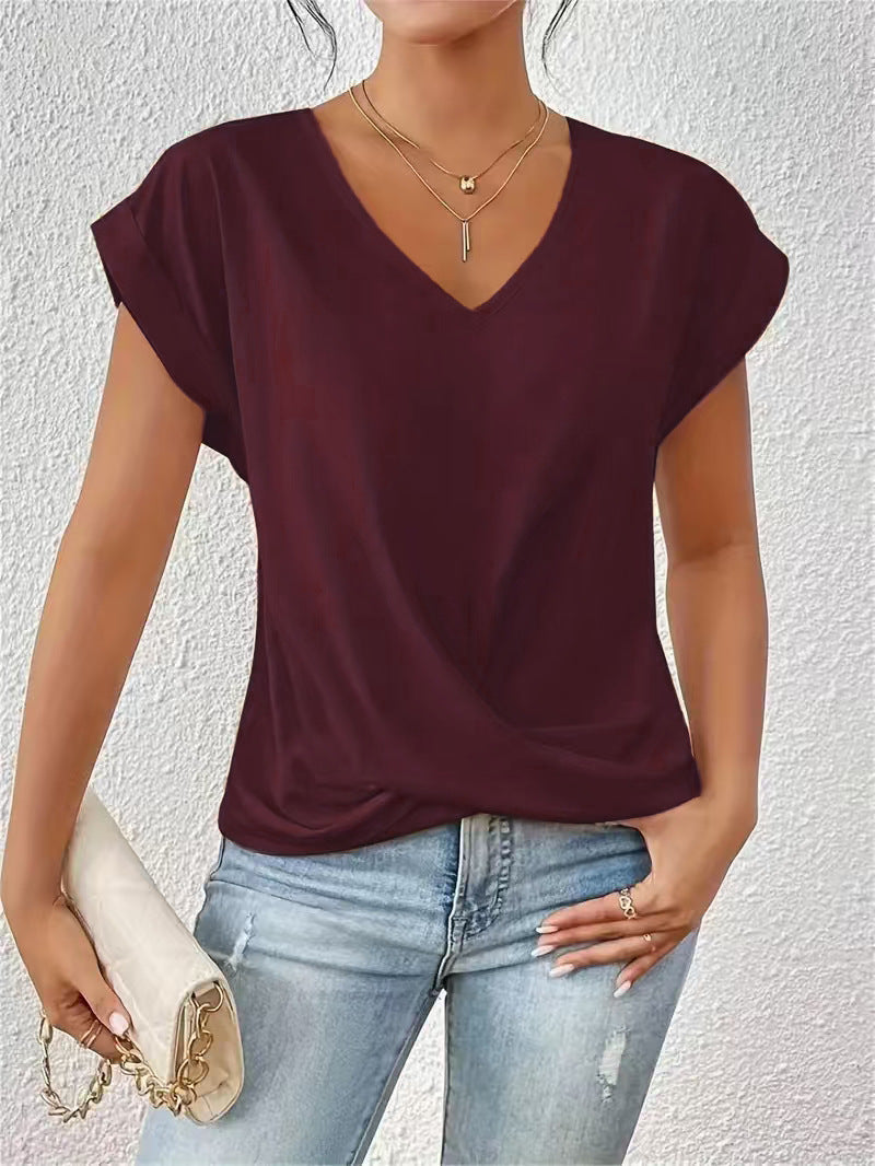 Woman wearing a burgundy top and light blue jeans against a white background
