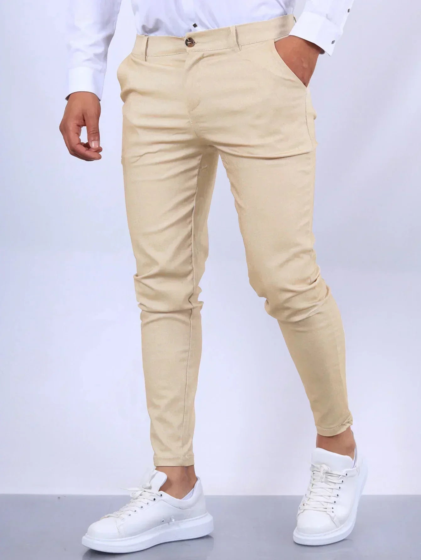 Beige pants worn by a person on a white background