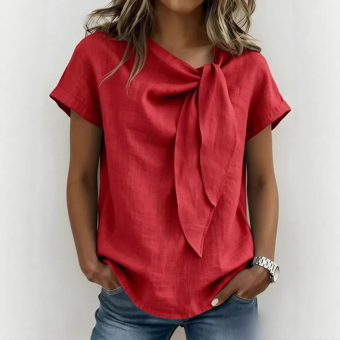 Person wearing a red top with a scarf tied around the neck against a white background