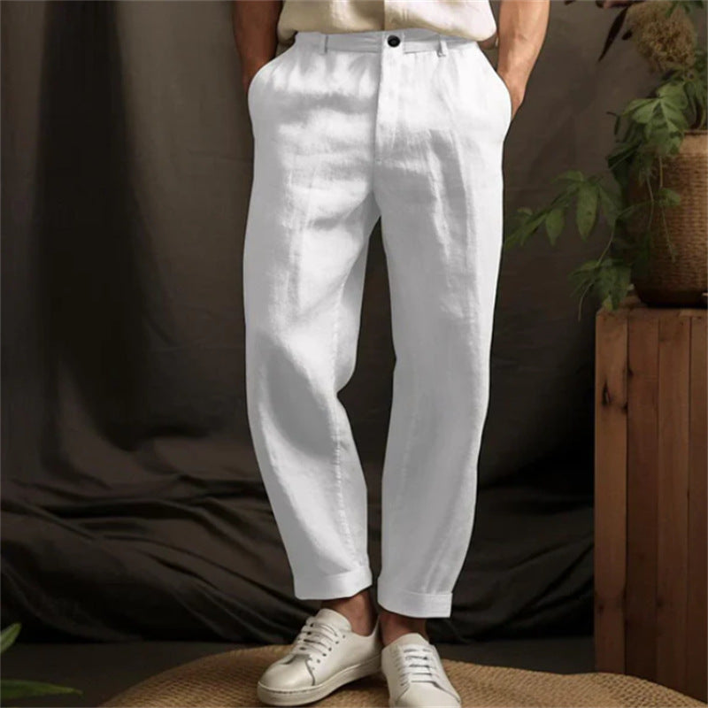Person wearing white pants standing against a brown background