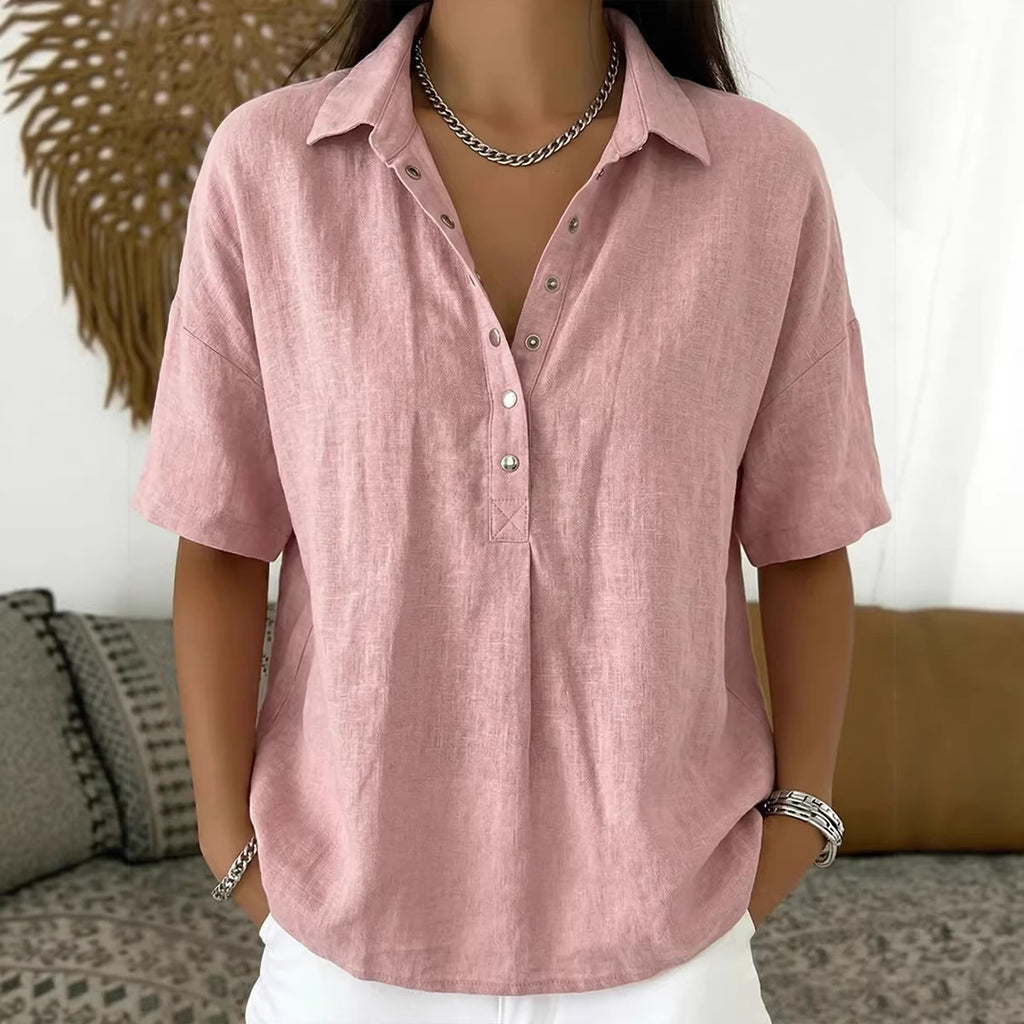 Person wearing a pink short-sleeve shirt with a neutral background