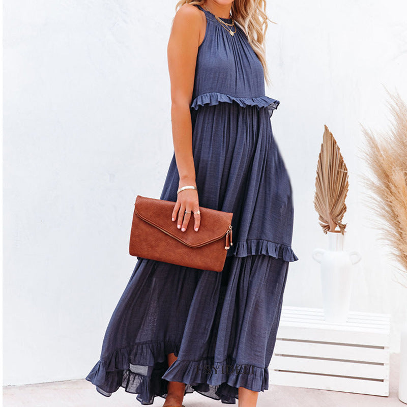 Woman wearing a blue dress holding a brown clutch against a white background
