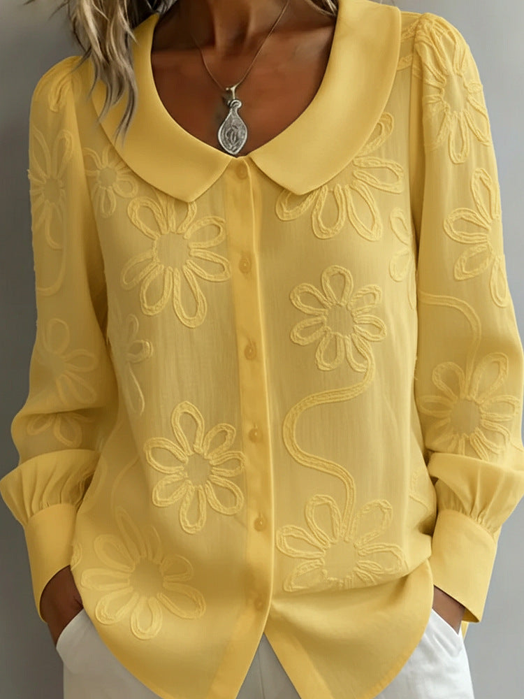 Yellow blouse with floral embroidery on a gray background