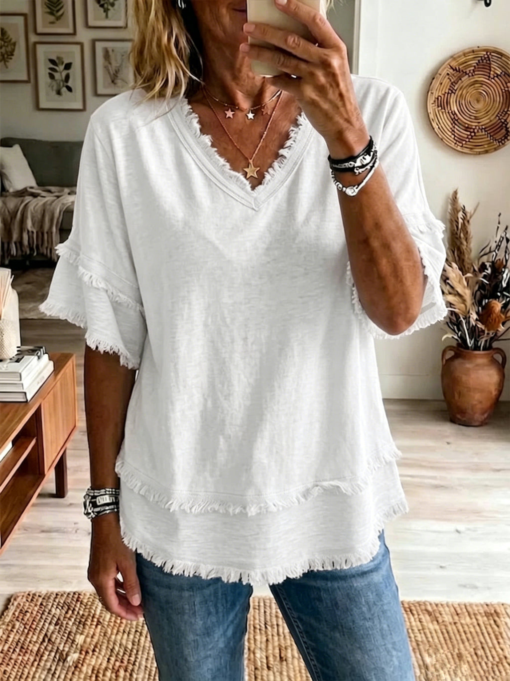 Person wearing a white blouse with lace details in a home setting