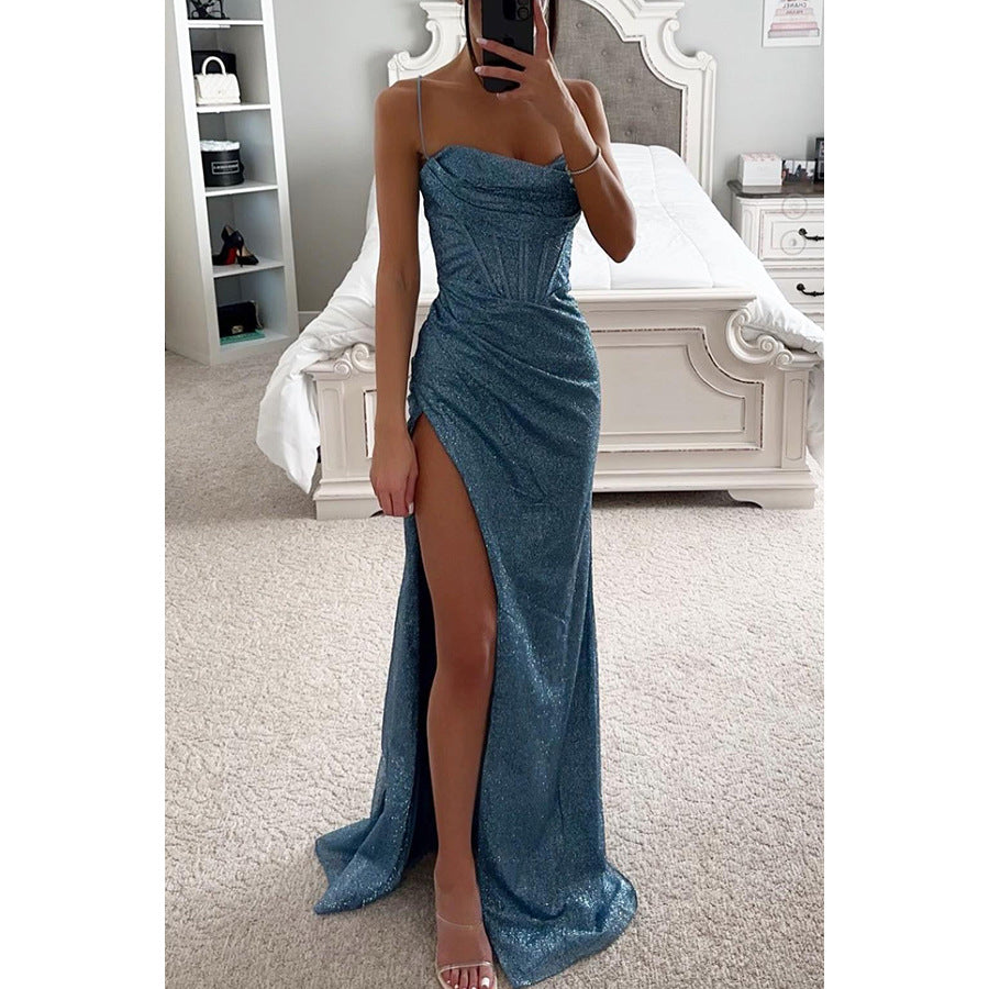 Woman wearing a blue strapless gown with a high slit in a bedroom setting.