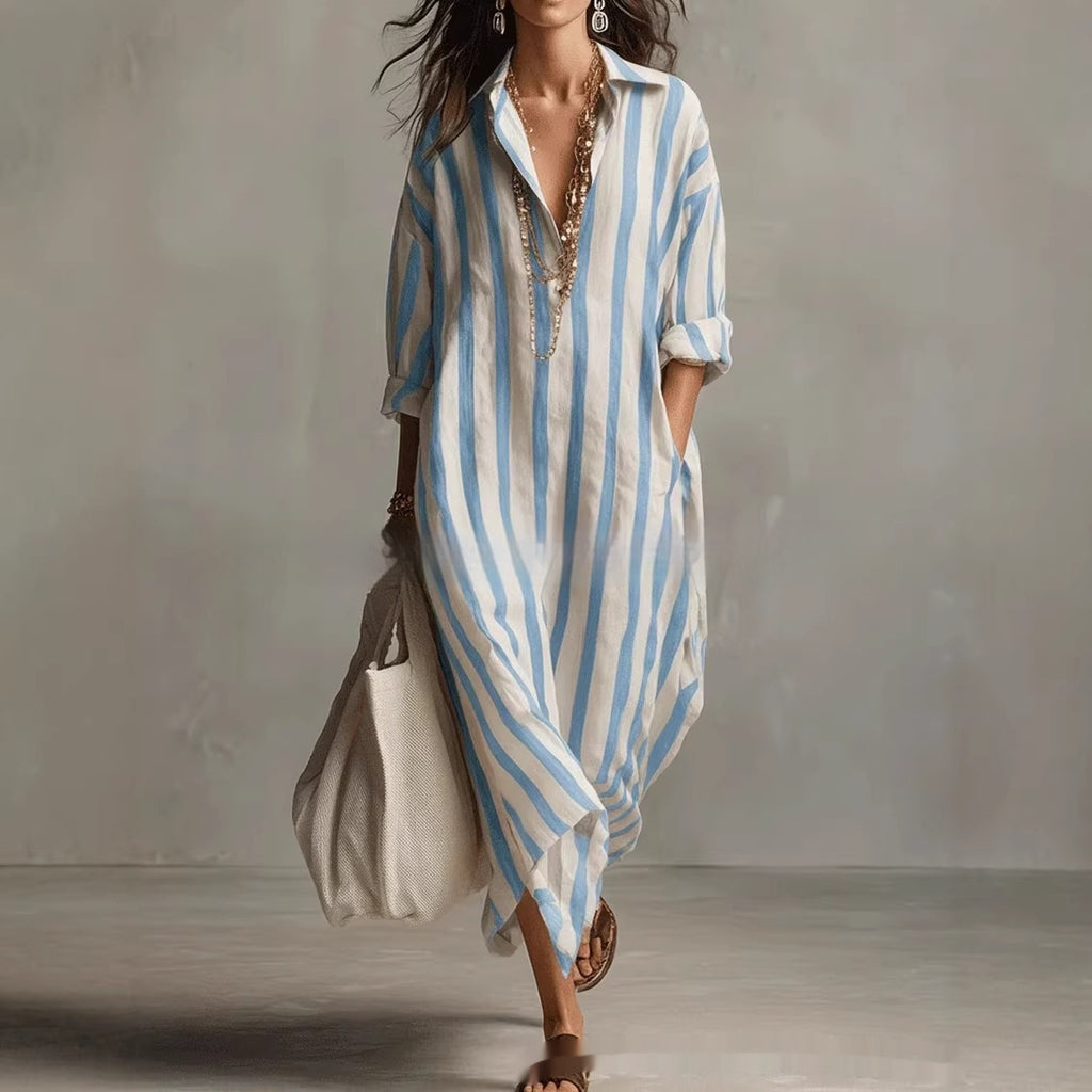 Woman wearing a long, light blue and white striped dress against a neutral background