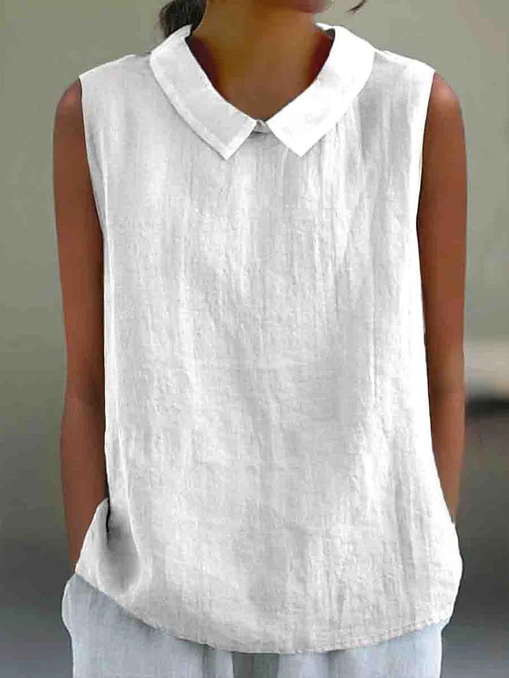 White sleeveless shirt with a collar worn by a person against a neutral background
