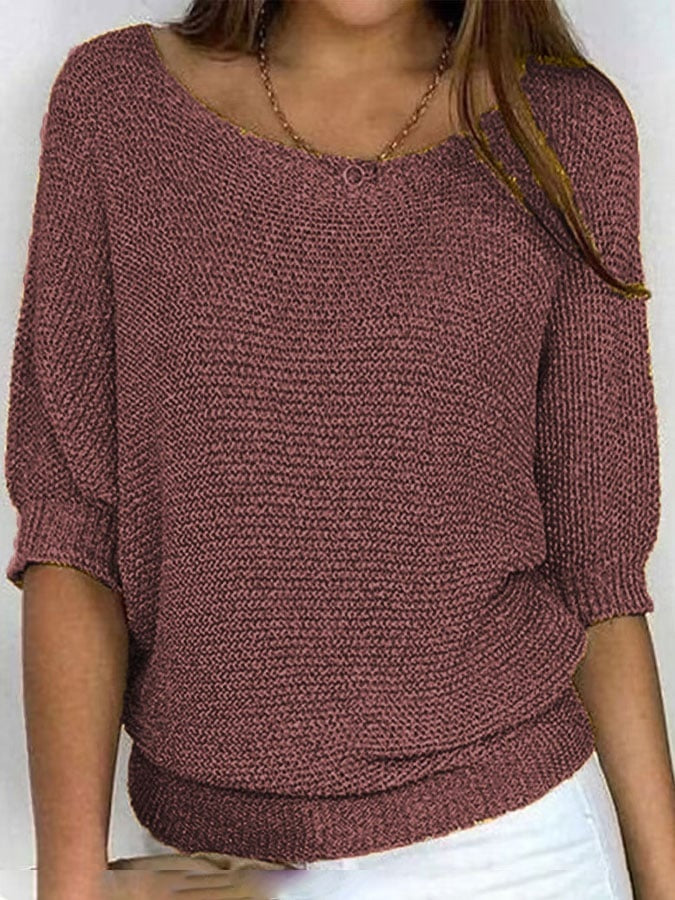 Person wearing a brown knitted sweater against a white background