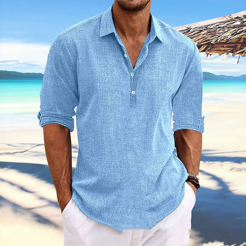 Man wearing a light blue shirt on a beach