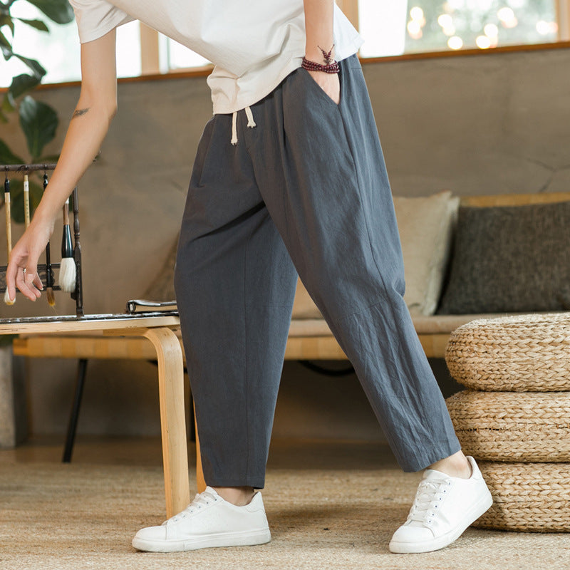 Person wearing gray pants and white sneakers in a living room setting