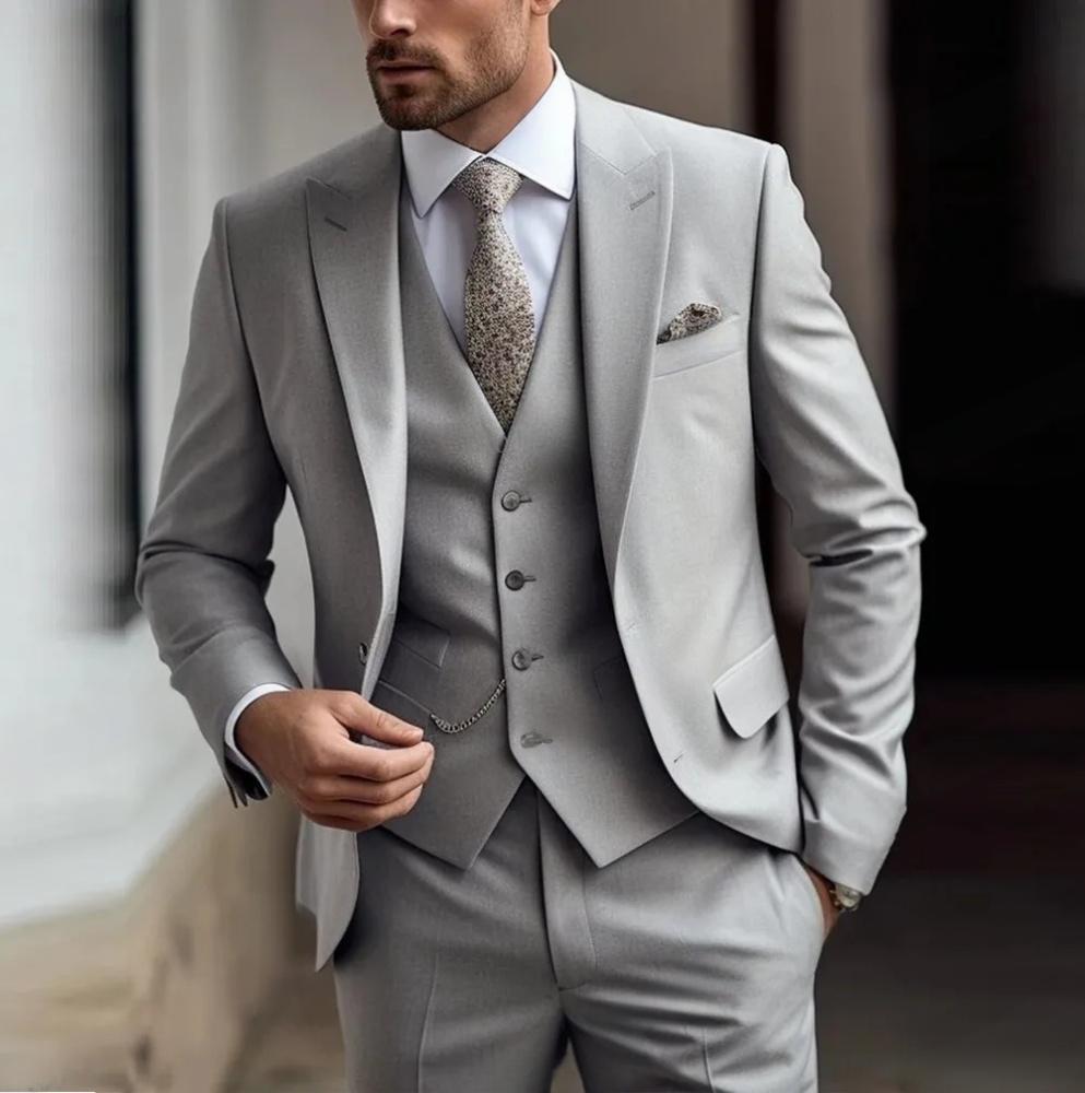 Man wearing a gray suit with a patterned tie against a blurred background