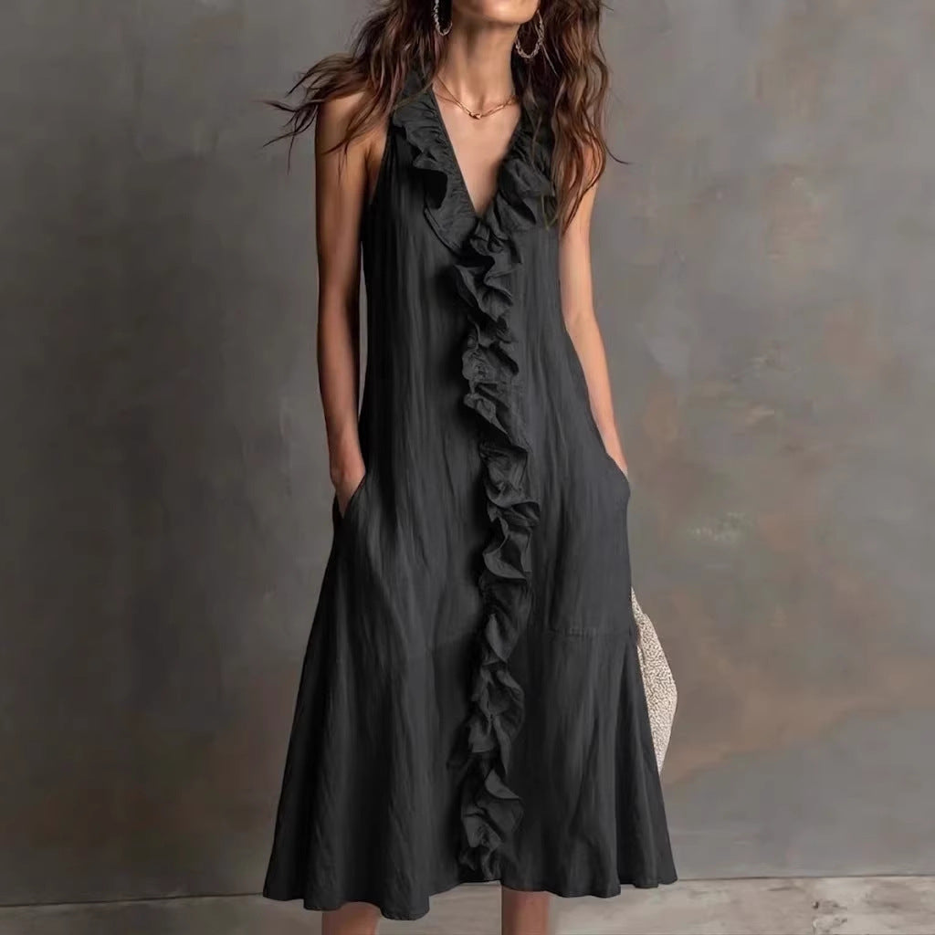 Woman wearing a black ruffled dress against a gray background