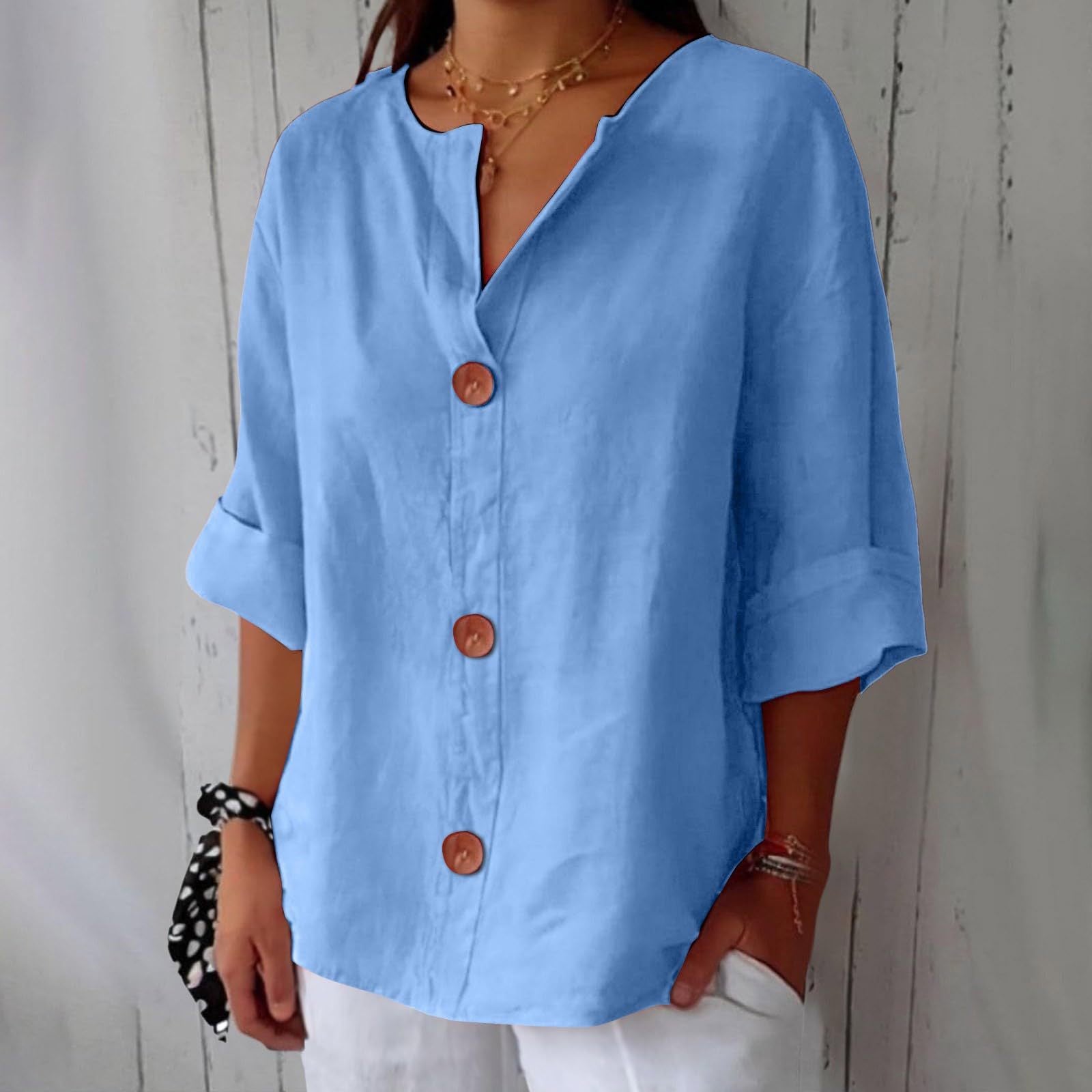 Person wearing a light blue button-up shirt with a neutral background