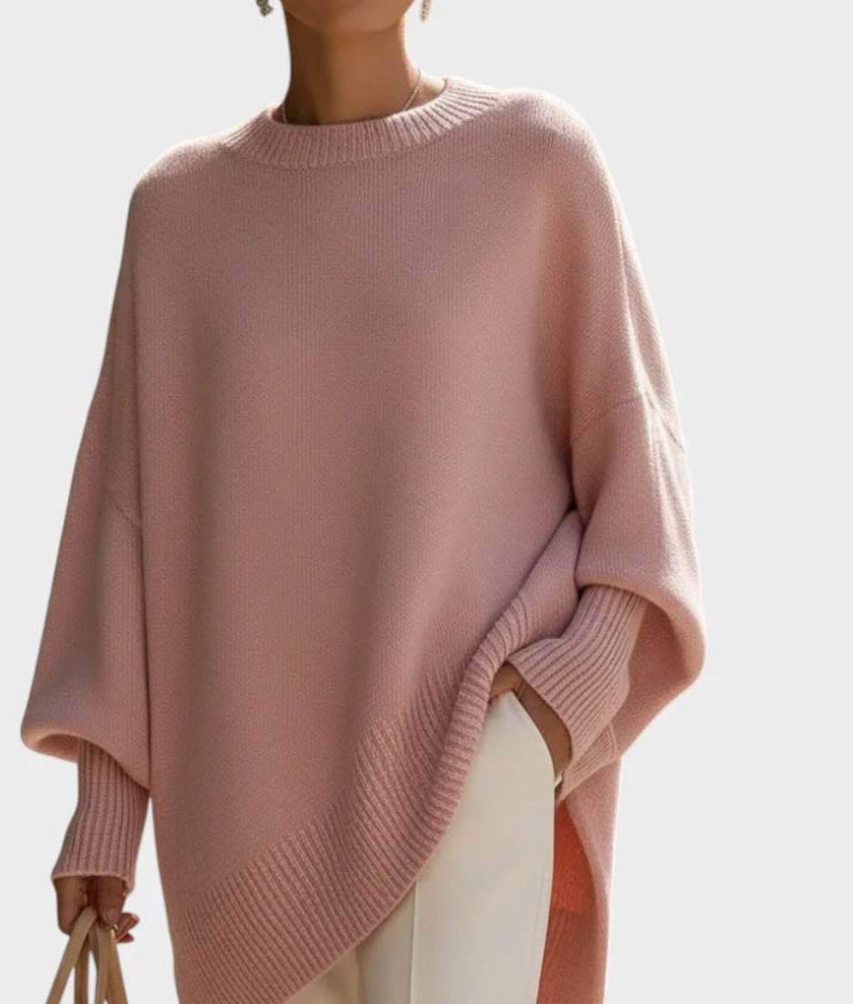 Pink poncho worn by a person on a light gray background