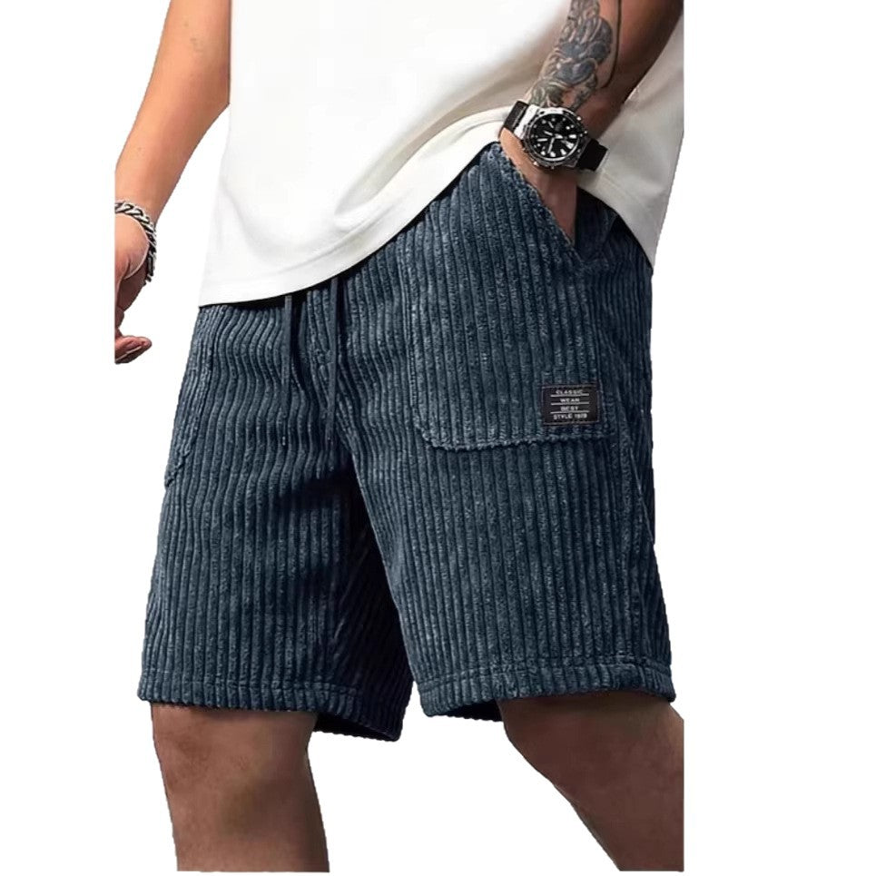 Blue corduroy shorts worn by a person on a white background