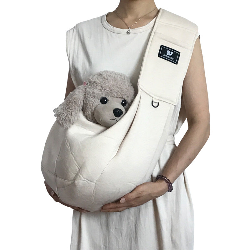 Person holding a white baby carrier with a gray teddy bear inside, on a white background.